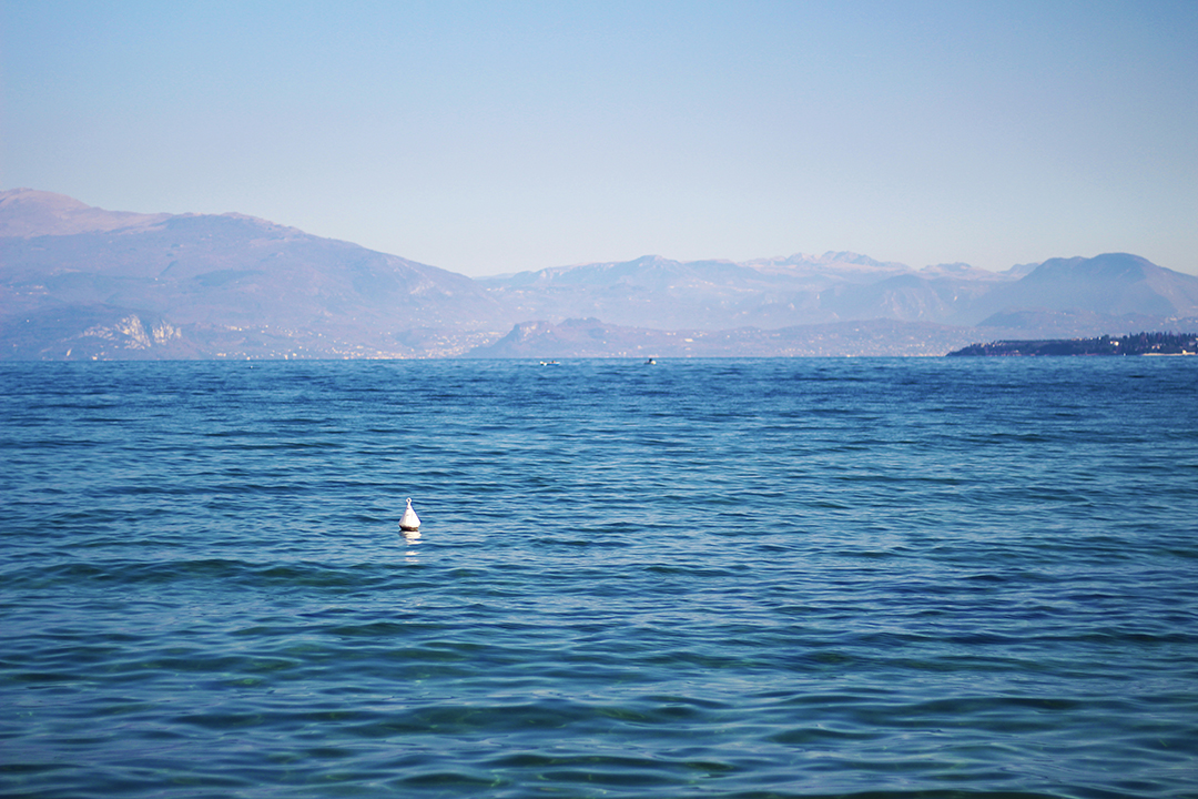 Am Gardasee mit schwarzer Hose und braunem Pullover